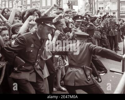 Die Polizei kämpft, um die Massen von Beatles-Fans zurückzuhalten, als die englische Rockband am 5. Juni 1964 nach Amsterdam, Nordholland kam. Stockfoto