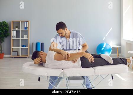 Chiropraktiker, Osteopath, Physiotherapeut oder manuelle Therapeut hilft Patienten mit Rückenschmerzen Stockfoto