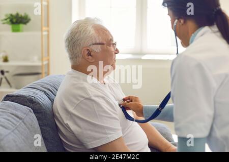 Doktor, der durch ein Stethoskop auf der Brust dem Herzen zuhört und einem älteren Mann atmet. Stockfoto