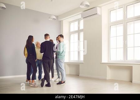 Freundlich verschiedene Büroangestellte oder Kollegen kommunizieren und sprechen am Fenster in der hellen Halle. Stockfoto