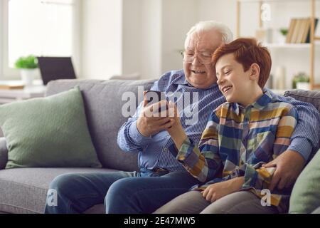 Enkel zeigt Opa, wie man Social Media nutzen oder machen Videoanruf auf Mobiltelefon Stockfoto