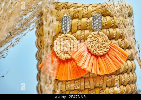 Natürliches handgemachtes Produkt, ein Paar Ohrringe auf dem Hintergrund des goldenen Schilfgrases. Umweltfreundliches und nachhaltiges Konzept. Umweltfreundliche Einkaufsmöglichkeiten und r Stockfoto