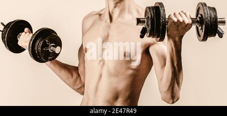 Mann im Sport mit Hanteln. Schwache Mann heben Gewicht, Hanteln, Bizeps, Muskeln, Fitness. Nerd maleraising eine Hantel. Mann mit Hantel in der Hand Stockfoto