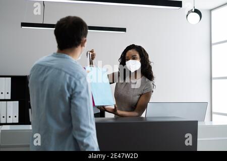 Kassierer Im Einzelhandel Oder Geschäft An Der Theke Tragen Gesichtsmaske Stockfoto