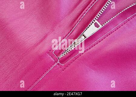 Reißverschluss an Kunstlederhose. Fuchsia eco Kunstleder Textur Hintergrund. Stockfoto