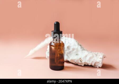 Leere Amber Glas Essential Flasche mit Gesichts-Serum auf beigem Hintergrund. Natürliche Bio-Kosmetik, nachhaltiges Lifestyle-Konzept. Vorderansicht, Kopie SPA Stockfoto