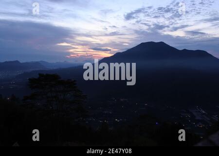 Dramatischer Sonnenuntergang Himmel über einem silhouetted Berg Stockfoto