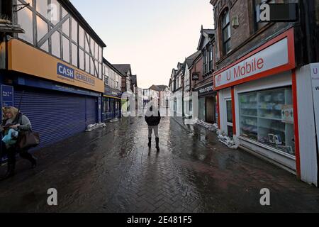 Ein Mann läuft durch das restliche Hochwasser außerhalb der Geschäfte im Stadtzentrum von Northwich, Cheshire, das während des Sturms Christoph überschwemmt wurde. Bilddatum: Freitag, 22. Januar 2021. Stockfoto