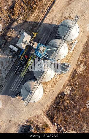 Top down view Moderne Stahl landwirtschaftliche Getreidespeicher Silos Getreidelager Laden Fracht Getreideträger bei Sonnenuntergang. Agribisness Ackerland Stockfoto