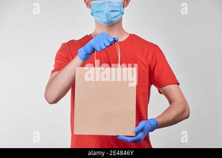 Mann, der eine Bestellung in einer Papiertüte verpackt liefert Stockfoto