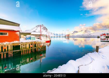 Erstaunlicher Wintersonnenaufgang über Ramberg Dorf und Hafen. Festgemacht Fischerschiffe im Hafen. Lage: Ramberg, Flakstadoya Insel, Lofoten; Norwegen, Europa Stockfoto