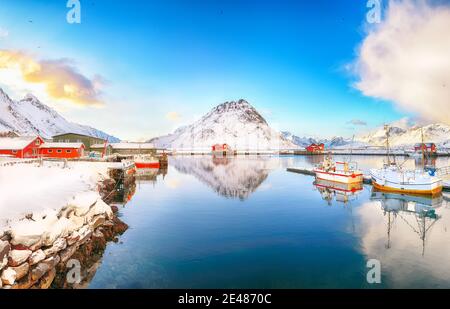 Erstaunlicher Wintersonnenaufgang über Ramberg Dorf und Hafen. Festgemacht Fischerschiffe im Hafen. Lage: Ramberg, Flakstadoya Insel, Lofoten; Norwegen, Europa Stockfoto