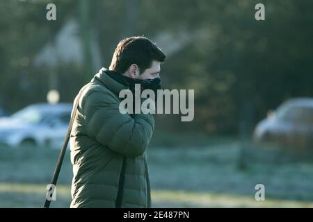 WIMBLEDON LONDON, GROSSBRITANNIEN 22. JANUAR 2021. Ein Mann deckt seinen Mund, wie er trotzt der kalten eiskalten Koniditonen in den frühen Morgen auf Wimbledon Common s Temperaturen fallen unter Null.. Kredit: amer ghazzal/Alamy Live Nachrichten Stockfoto