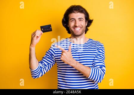 Foto der positiven mittleren östlichen Kerl zeigen Finger Kreditkarte Tragen Sie blau weißen Kittel isoliert auf hellgelben Hintergrund Stockfoto