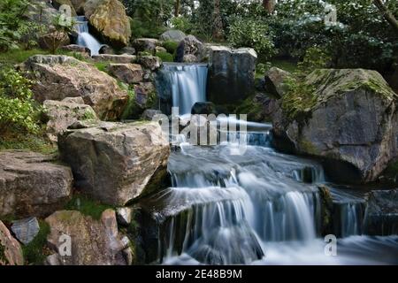Langer seidig glatter Wasserfall über felsigen Klippen im Kyoto Garden, Holland Park Stockfoto