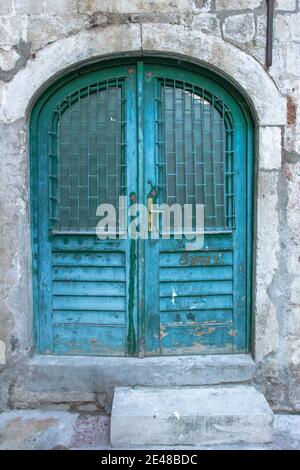 Wunderschöne vintage blau bemalte Tür. Blaue Grunge Holztür in Backsteinmauer. Alte rustikale Holztüren in Montenegro, Europa. Stockfoto