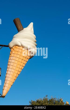 Großer Eiskegel mit Flockenwerbung an Southend am Meer an einem hellen Wintertag. Übergroße Eiscreme-Kornett-Schild in blauem Himmel. Anzeigen Stockfoto