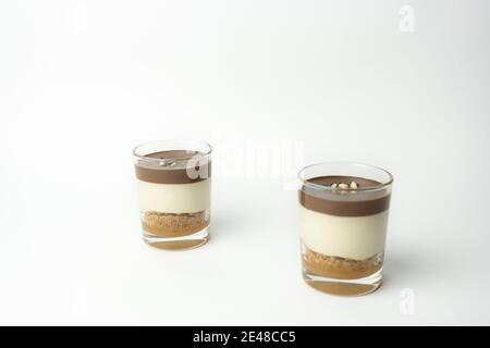 Zwei Schokoladendessert in Glas (Joghurt oder Sahne, Kekse und Nüsse) Süßigkeiten süße Konzept isoliert auf weißem Hintergrund. Stockfoto