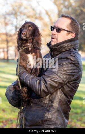 Northampton, Großbritannien, 22. Januar 2021. Ein sonniger Morgen in Abington Park für die Hunde Wanderer aus genießen das gute Wetter, Foto Lloyd Carrington und sein Haustier Peanut ein schokoladenfarbener Spaniel immer in der täglichen Übung. Kredit: Keith J Smith./Alamy Live Nachrichten Stockfoto