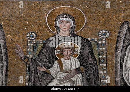 Die Heilige Maria hält das Jesuskind, während sie auf einem juwelenbesetzten Thron sitzt. Detail des byzantinischen Mosaiks in der Basilica di Sant’Apollinare Nuovo in Ravenna, Emilia-Romagna, Italien. Das Mosaik entstand in den 500er Jahren n. Chr. Stockfoto