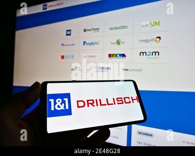 Person mit Telefon mit Logo des deutschen Telekommunikationsanbieters 1und1 Drillisch AG auf dem Display. Konzentrieren Sie sich auf die Mitte des Smartphone-Bildschirms. Stockfoto