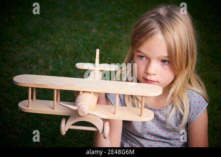 Träume vom Flug! Kind spielt mit Spielzeug Flugzeug. Glückliches Kind träumt von Reisen und Spielen mit einem Flugzeug im Freien im Sommer Stockfoto