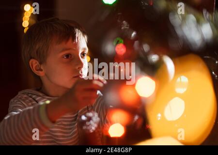 Porträt von 8 Jahre alten Jungen Dekoration Weihnachtsbaum Stockfoto