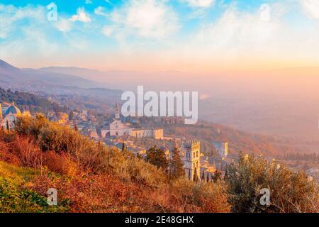 Atemberaubende Aussicht auf Assisi, Provinz von Umbrien Stadt Skyline und Wolkenkratzer bei Sonnenuntergang. Schöne Nacht Blick vom Hügel, gesehen St. Francis Kirche oder Stockfoto