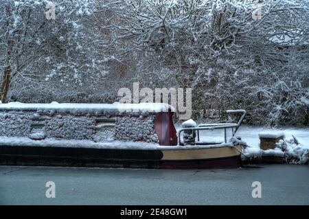 Dieses gefrorene Kanalschmalboot wurde auf dem Kennet und Avon Kanal bei Kintbury in Berkshire während eines kalten Schnapps fotografiert. Der Kanal war gefroren und das b Stockfoto