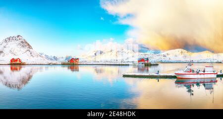 Erstaunlicher Wintersonnenaufgang über Ramberg Dorf und Hafen. Festgemacht Fischerschiffe im Hafen. Lage: Ramberg, Flakstadoya Insel, Lofoten; Norwegen, Europa Stockfoto