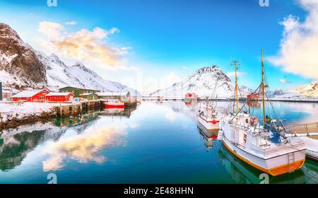 Erstaunlicher Wintersonnenaufgang über Ramberg Dorf und Hafen. Festgemacht Fischerschiffe im Hafen. Lage: Ramberg, Flakstadoya Insel, Lofoten; Norwegen, Europa Stockfoto