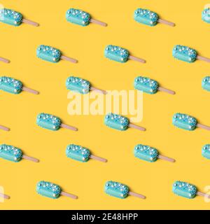Blaue Minze Eis Eis Eis Eis Eis auf gelbem Hintergrund. Leckeres und erfrischendes Eis auf Stöcken. Nahtloses Muster, minimalistisches Sommerkonzept. Flach liegend. Stockfoto
