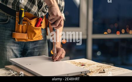 Mann, der während des Prozesses der Möbelherstellung arbeitet Stockfoto