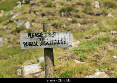 Auf einem Felsfeld in Nidderdale, North Yorkshire, England, ist ein altes Holzschild mit der Aufschrift „Please keep to the Public Footpath“ (Bitte halten Sie sich auf dem öffentlichen Fußweg) zu sehen. Stockfoto