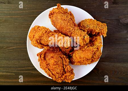 Platte mit köstlichen Golden Brown Crispy gebratene Hühner auf Holz Hintergrund Stockfoto