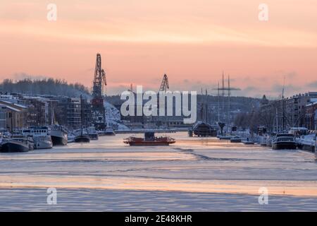 TURKU, FINNLAND - Föri Fähre auf gefrorenem Aurajoki Fluss bei Sonnenuntergang. Stockfoto