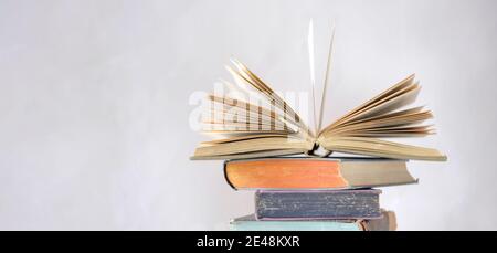 Geöffnetes Buch und Stapel von Buch, Lesen, Bildung, Home Office, zurück zur Schule Konzept, engen Fokus, freie Kopieplatz Stockfoto