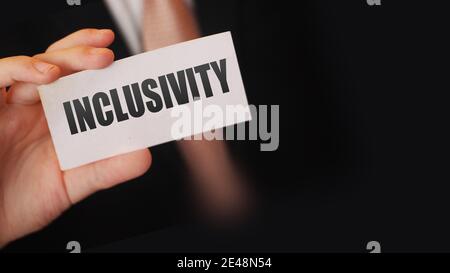 Inklusivität auf einer Karte in der Hand eines Geschäftsmannes geschrieben. Vielfalt und Toleranz am Arbeitsplatz Business Teamwork Social wellfare Konzept. Stockfoto