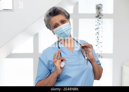 Porträt einer älteren afroamerikanischen Ärztin, die ein Gesicht trägt Maske, die auf die Kamera schaut Stockfoto