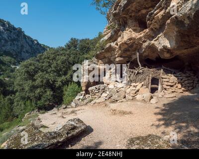 Blick auf die alte Höhle shepard Schutz auf Wanderweg zu Cala Goloritze Strand mit Kalkstein Felsen, Bäume, grünen Busch. Golf von Orosei, Sardinien, Italien, Sept Stockfoto