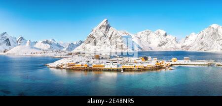 Luftaufnahme Winter Blick auf Sakrisoy Dorf und verschneite Berge im Hintergrund. Beliebtes Touristenziel auf Lofotens. Ort: Sakrisoy , Moskenesoya Stockfoto
