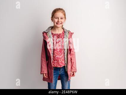 Kleines Mädchen in rosa Jacke stehen drinnen Stockfoto