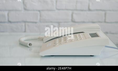Mann trägt Schutzhandschuhe in den Händen Machen Sie einen Telefonanruf Über Das Bürotelefon Stockfoto