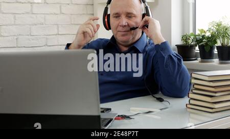 Mann, der von zu Hause aus in einem Videoanruf mit spricht Laptop-Anschluss Stockfoto