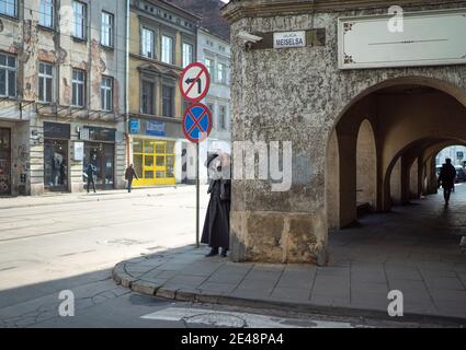 Polnischer Priester fotografiert traditionelle städtische Straßenszene mit Filmkamera In Krakau Osteuropa High Street Geschäfte Polen Architektur Tourist Stockfoto