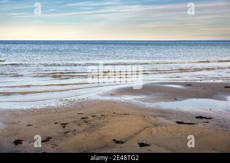 Nasser Sandstrand, ruhige Wellen und Blick über das Wasser bis zum Horizont an der Ostsee in Norddeutschland, Kopierraum, ausgewählter Fokus, enge Tiefe von f Stockfoto