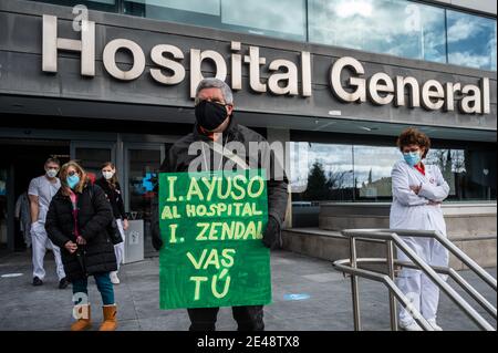 Madrid, Spanien. Januar 2021. Ein Mann mit einem Plakat protestiert im La Paz Krankenhaus während einer Demonstration gegen die erzwungene Überführung von Gesundheitspersonal in das neue Notkrankenhaus Isabel Zendal. Demonstranten protestieren gegen die Bewältigung der Krise des Coronavirus (COVID-19) durch die Regionalpräsidentin von Madrid Isabel Diaz Ayuso. Quelle: Marcos del Mazo/Alamy Live News Stockfoto