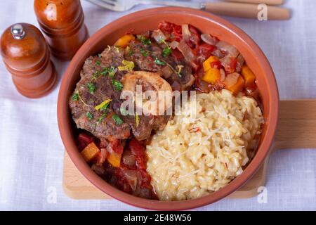 Ossobuco. Kalbsschenkel mit Safranrisotto in mailänder, Gremolata und Sauce. Traditionelles italienisches Gericht. Nahaufnahme. Stockfoto