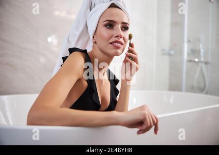 Hübsche Frau mit einer Gesichtsmassage zu Hause Stockfoto