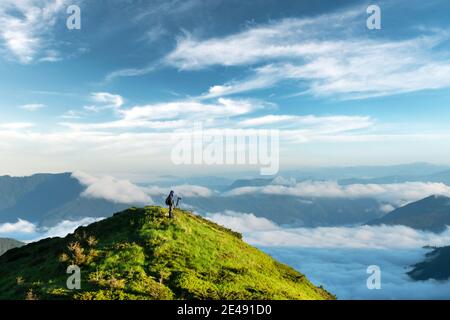 Landschaftsfotograf fotografiert neblige, wolkige Berge. Reisekonzept, Landschaftsfotografie Stockfoto